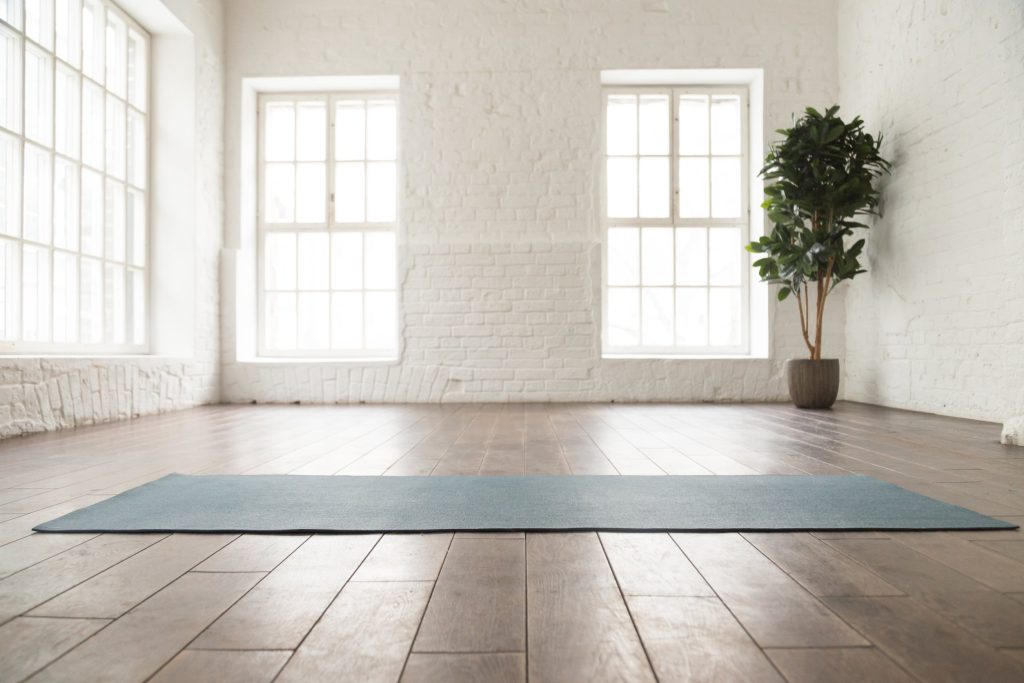 Yogaøvelser mot korsryggsmerter. Bildet viser et yogaværelse som er tomt.
